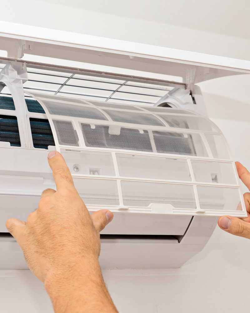 someone replacing air filter on ac unit